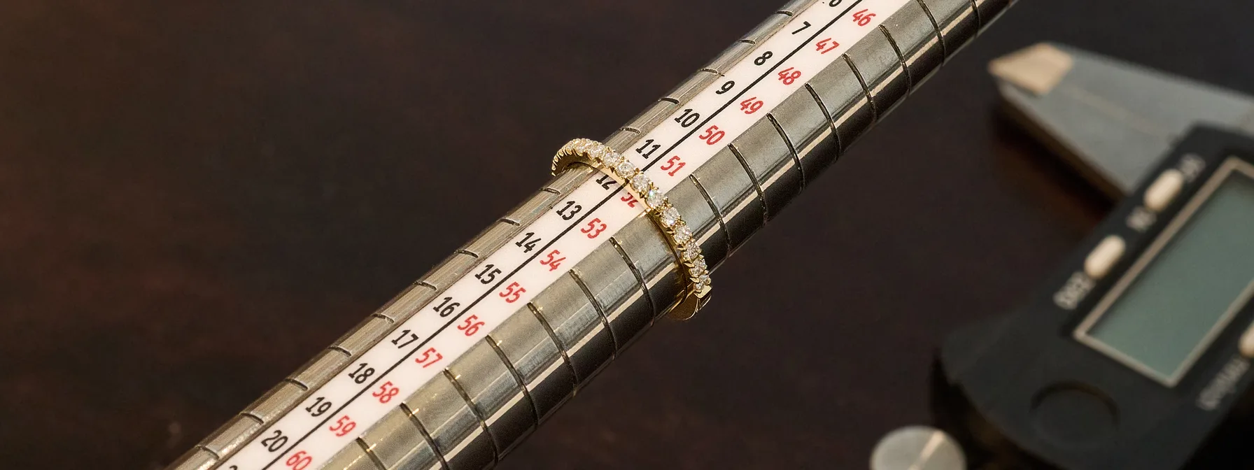 Schmaler Goldring mit Diamanten auf einem Ringstock, er bleibt bei Ringgröße 52 stehen